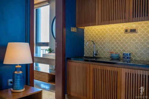 a kitchen with a sink and a table with a lamp at Seahorse Han Market Da Nang Apartment by Haviland in Danang