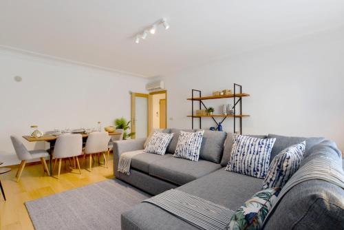 a living room with a gray couch and a table at Gorgeous Beach Apartment - Checkinhome in Carcavelos