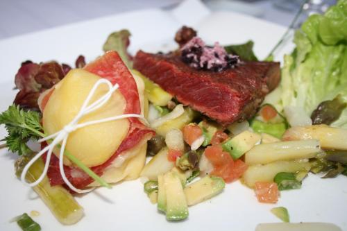 a white plate of food with vegetables and meat at Chambres Rozies Dunes in Dunes
