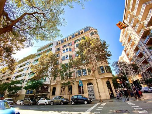 Un edificio alto con coches aparcados delante. en Hostal Madrazo, en Barcelona