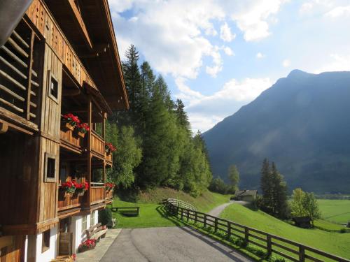 un edificio con flores en los balcones y una montaña en Beim Untertimmeltaler, en Matrei in Osttirol