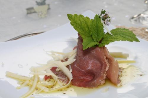 a piece of meat on a plate with pasta at Chambres Rozies Dunes in Dunes