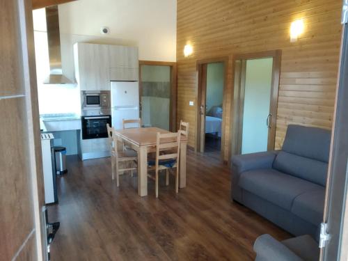 een keuken en een woonkamer met een tafel en een bank bij Apartamentos Rurales Casa Fonso in Navia