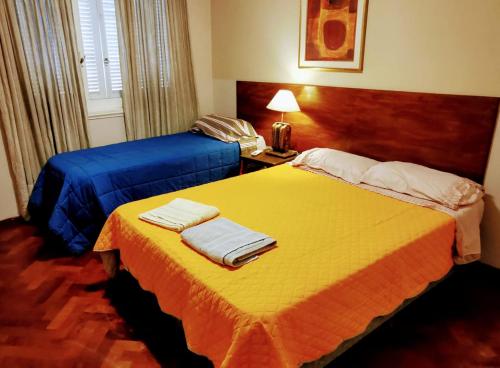 Habitación de hotel con 2 camas y toallas. en Plaza España en Mendoza