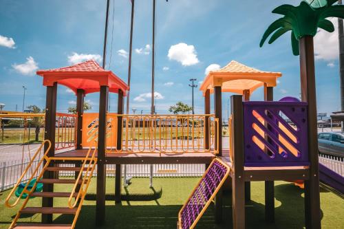 a playground with a slide and swings at Hotel 10 Itajai/Navegantes in Itajaí