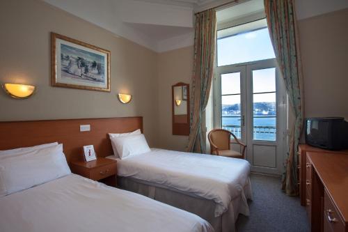 Un pat sau paturi într-o cameră la The Grand Hotel