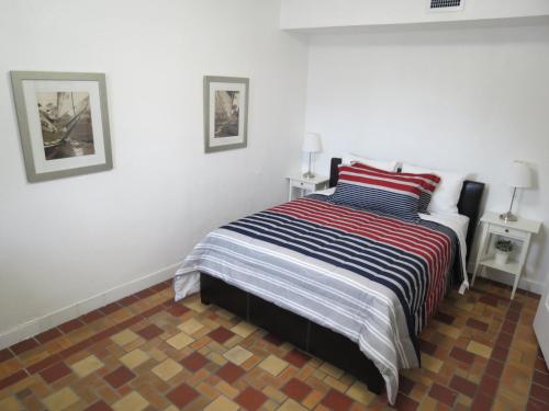 a bedroom with a bed with a striped blanket at Harding Boutique Apartments in Miami Beach