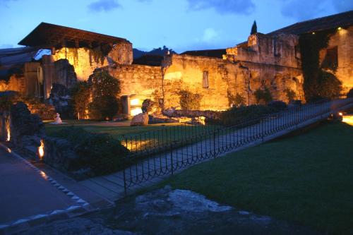 a large stone building with a pond in front of it at Hotel Museo Spa Casa Santo Domingo in Antigua Guatemala