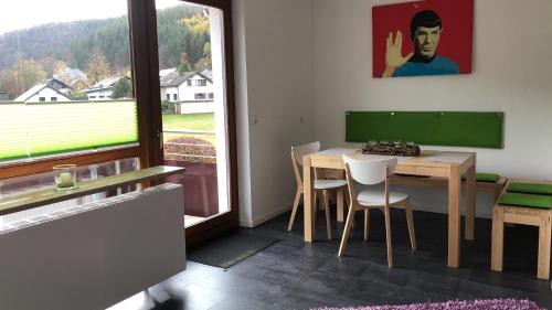 uma sala de jantar com uma mesa e cadeiras e uma janela em FeWo Stryck Idyllika em Willingen