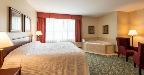 a hotel room with a bed and a bath tub at Vinifera Inn in Geneva