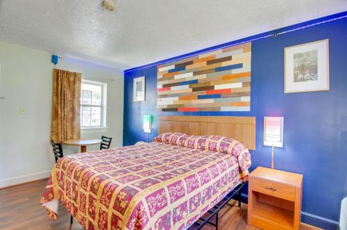 ein Schlafzimmer mit einem Bett und einer farbenfrohen Wand in der Unterkunft Scottish Inns Collinsville - Martinsville in Collinsville