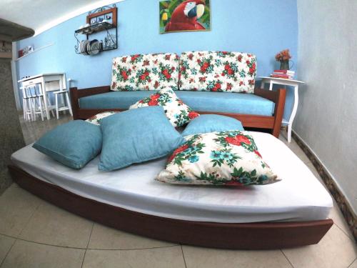 uma cama com almofadas num quarto em Recanto do Lago Buzios em Búzios