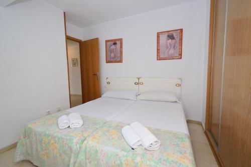 a bedroom with a bed with white shoes on it at Los Caballos - Fincas Arena in Benidorm