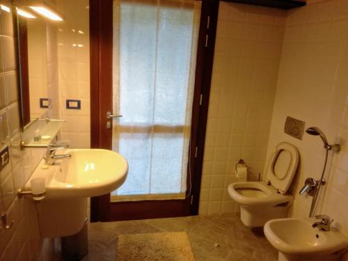 a bathroom with a sink and a toilet and a window at La casetta di Coradosso in Selvapiana
