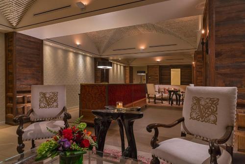 a lobby with two chairs and a table with flowers at Hotel Valencia Santana Row in San Jose