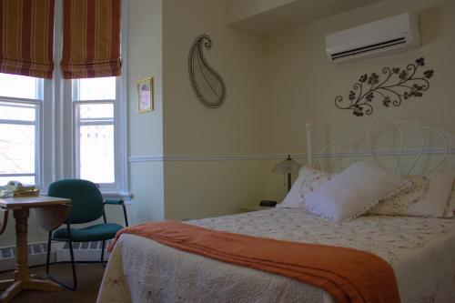 a bedroom with a bed and a table and a window at Garden South Park Inn in Halifax