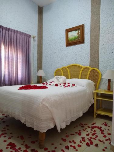 a bedroom with a bed with red roses on it at Hotel Villa Monarca Inn in Zitácuaro
