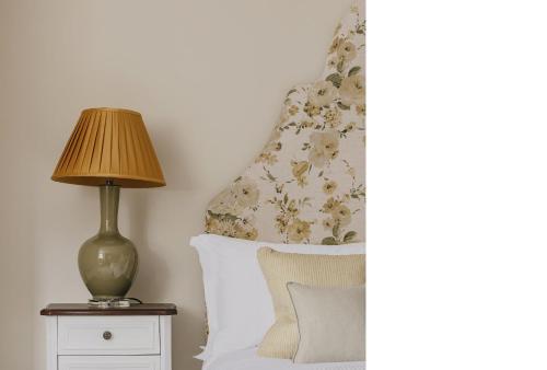 a bedroom with a bed with a lamp on a night stand at Tyndall Villa Boutique B&B in Bath