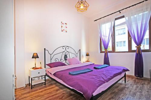 sypialnia z dużym łóżkiem z fioletową pościelą w obiekcie Top Center Relax, NDK & Vitosha str, FREE Secured parking w mieście Sofia