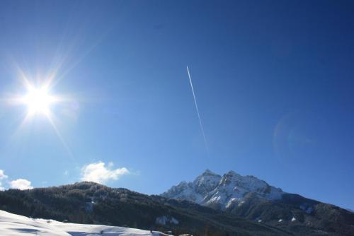a snow covered mountain with the sun in the sky at Haus Hubertus in Mieders