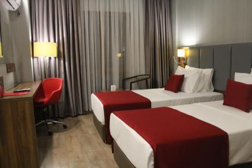 a hotel room with two beds and a desk at Ramada by Wyndham Van in Van