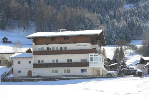 a large building in the snow in front of a mountain at Haus Hubertus in Mieders