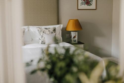 a bedroom with a bed with a lamp on a table at Tyndall Villa Boutique B&B in Bath