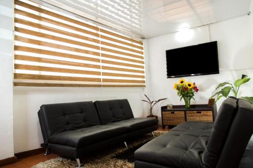 a living room with a couch and a flat screen tv at Deportel Bogotá in Bogotá