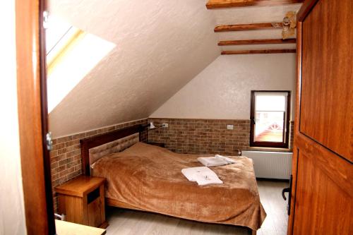 a bedroom with a bed in a attic at Zatyshok nad Prutom in Bukovel