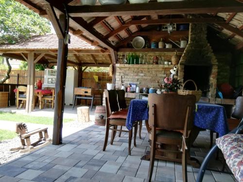 un patio con mesa, sillas y chimenea en Bóbita Apartmanház en Szilvásvárad