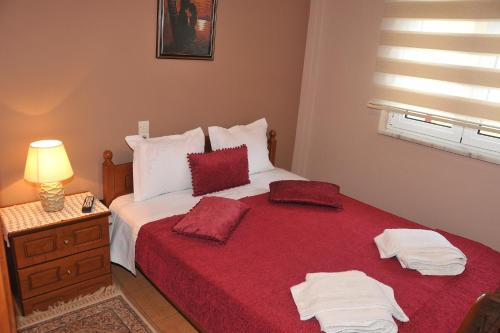 a bedroom with a red bed with two towels on it at Room Ntina Kastraki in Kastraki