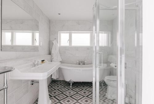 a bathroom with a tub and a sink and a toilet at Tyndall Villa Boutique B&B in Bath