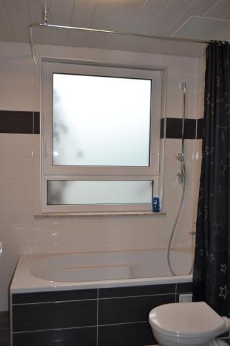 ein Bad mit einem Fenster, einem Waschbecken und einem WC in der Unterkunft Ferienwohnung Krone in Sankt Johann