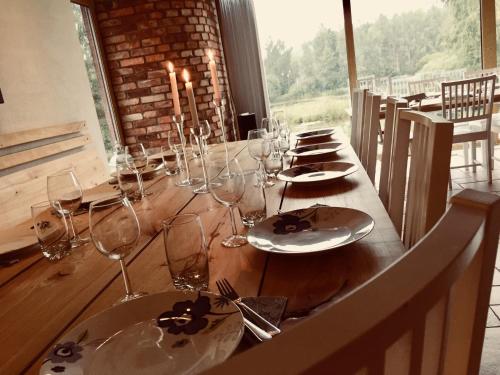 a long wooden table with glasses and plates on it at Sjöborg Säng & Bassäng in Munka-Ljungby