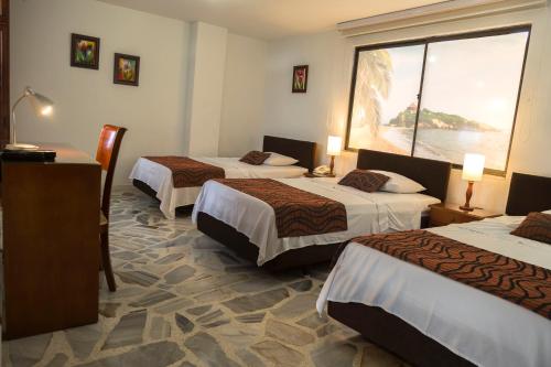 pokój hotelowy z 3 łóżkami i dużym oknem w obiekcie Hotel Flamingo Cali w mieście Cali