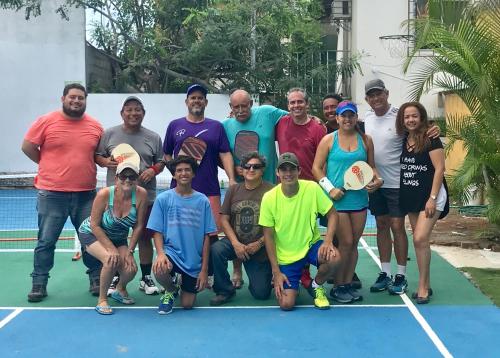 a group of people posing for a picture on a tennis court at Casa Blue Tortuga in Ballenita