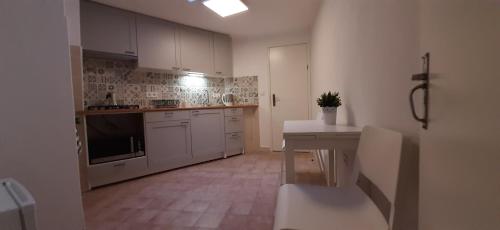 a kitchen with white cabinets and a white counter top at Trevim in Lousã