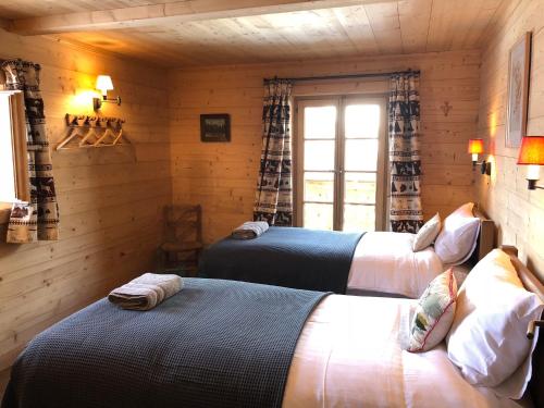 two beds in a room with a window at Boutique Chalet Panoramic Views Hot Tub in Vers L'Eglise