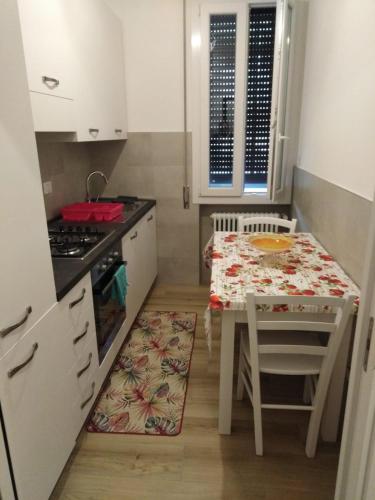 una pequeña cocina con mesa, mesa pequeña y silla en FAMILY en Bolonia