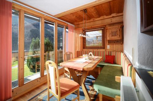 een eetkamer met een tafel en stoelen en een groot raam bij MH Appartement Hochwimmer in Saalbach Hinterglemm