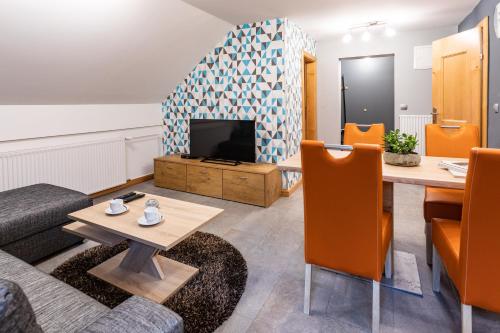 a living room with a table and a tv at Apartma Borovnica Rogla in Vitanje