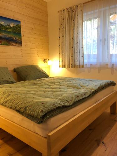 a bed in a room with a window at Ausseer Chalet (nahe Hallstatt), Appartements in Bad Aussee