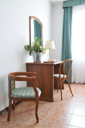 a desk with a chair and a mirror and a table at Ancora Sport Resort Hotel in Meolo