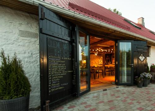 a restaurant with a cafe sign on the side of a building at Vetsi Talli Holiday Village in Kassari