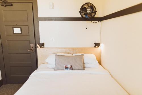 a bedroom with a bed with a clock on the wall at The Society Hotel in Portland