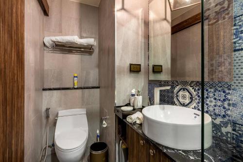 a bathroom with a white toilet and a sink at PALMYRAH SURIN, MODERN 1BR with Terrace, 150 meters to Surin Beach in Surin Beach