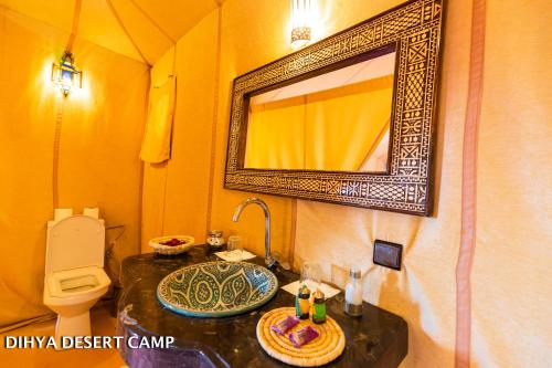 a bathroom with a sink and a toilet and a mirror at Dihya desert camp in Merzouga