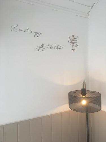 a lamp in a room with a sign on the wall at Appartements La Durance et L'Helpe in Embrun
