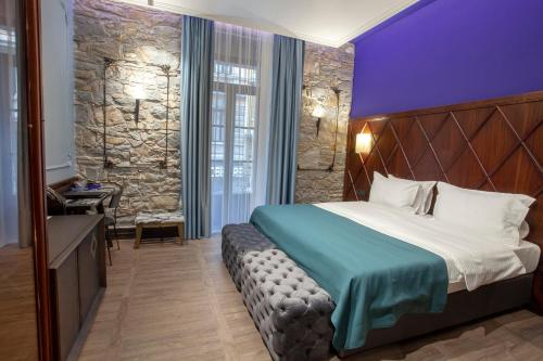a hotel room with a bed and a stone wall at Hotel Solun in Trieste
