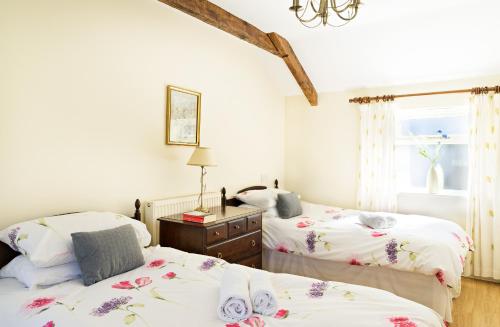 a bedroom with two beds and a window at The Neuadd Cottages in Crickhowell